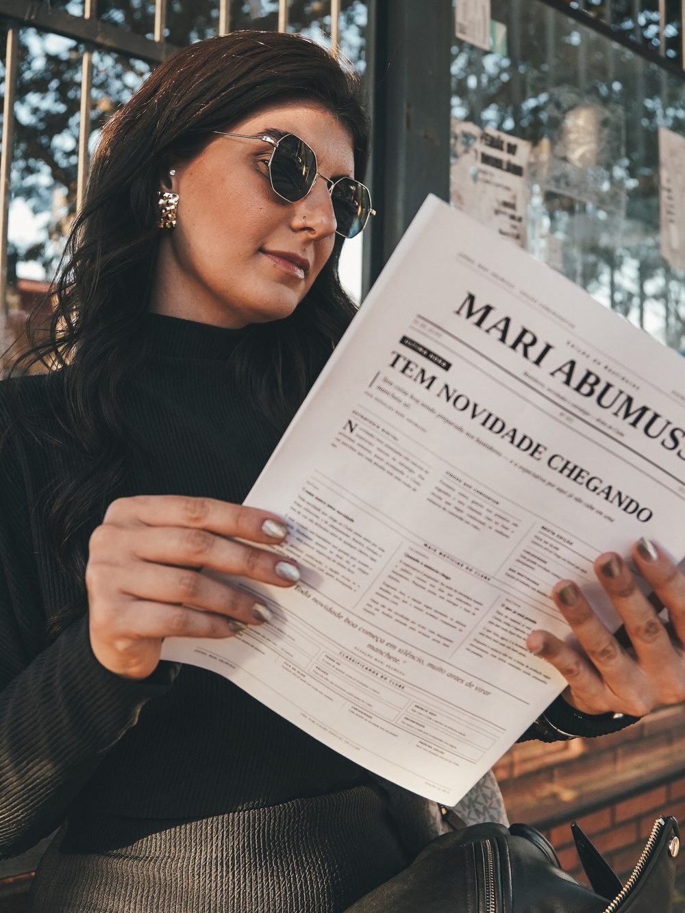 Mari lendo o jornal do ensaio, com o nome dela na capa